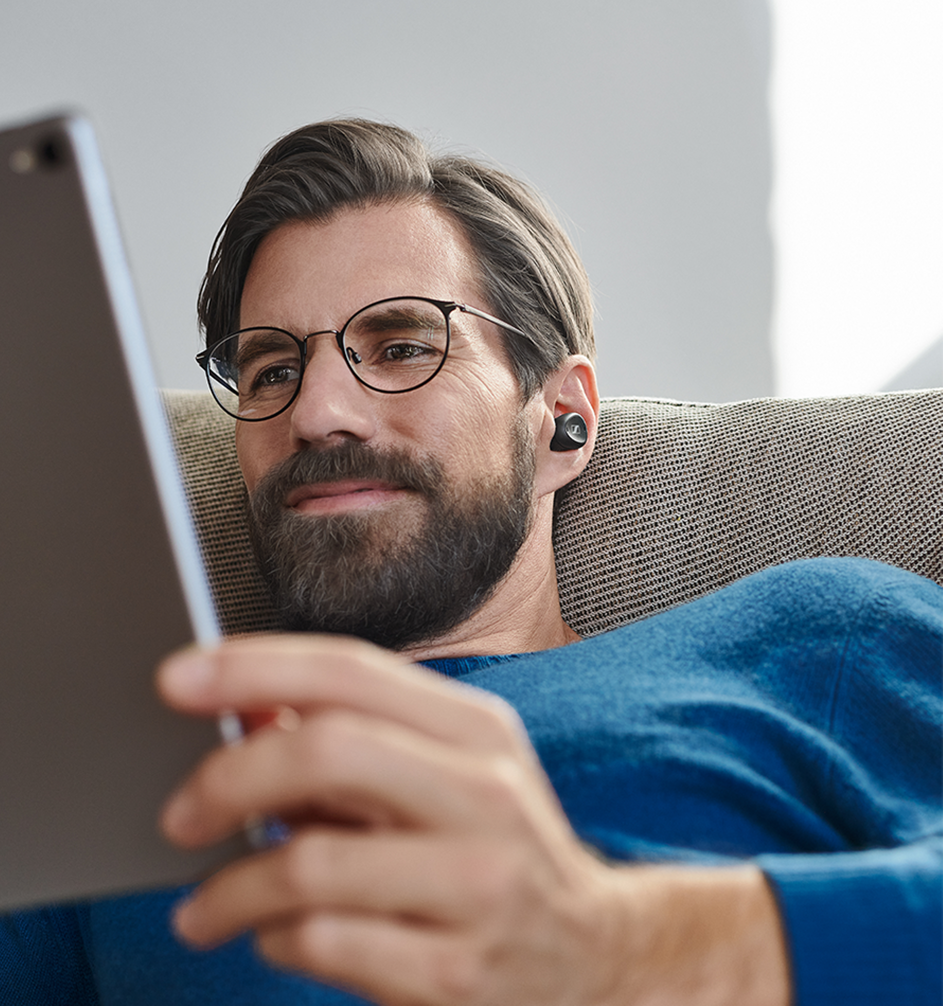 Man with TV Clear while watching something on his tablet